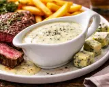 Steak juteux avec frites et une sauce au bleu crémeuse, parfaite pour accompagner.