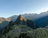 Machu Picchu i Peru, med solstrålar som bryter igenom molnen. En resa hit kan kräva vaccination Peru.