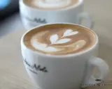 Zwei Tassen mit Latte Art, ein Herzmuster auf dem cremigen Schaum. Der perfekte Cappuccino für einen gemütlichen Morgen.