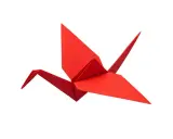 Ein roter Papierkranich, kunstvoll gefaltet als Origami.