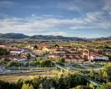 Vista aérea de un pueblo con tejados rojos y montañas al fondo. Se ve la bodega RODA, un buen lugar para añada 2017 rioja.