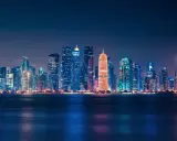 Glitzernde Skyline von Doha bei Nacht, ein Symbol für das moderne Katar.