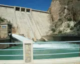 El embalse del Cenajo libera agua a través de un gran conducto, creando una cascada espumosa en el río.