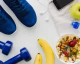 Gesunde Ernährung vor dem Halbmarathon: Haferflocken mit Früchten, Bananen, Apfel, Wasser und Sportutensilien.