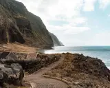Steile Klippen, das Meer und kleine Häuser – ein **Madeira must see**! Ein Weg führt entlang der Küste.