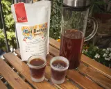Kalter Kaffee in Gläsern auf Holztisch. Daneben eine Karaffe mit Kaffee und eine Packung "Del Bosque honey". Ein kühler Genuss an einem warmen Tag.