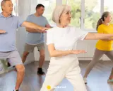 Seniorzy ćwiczą tai chi na krześle, poprawiając równowagę i spokój.