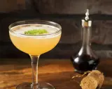 En läcker cocktail med mynta, en flaska mörk vätska och en kork. En klassisk old cuban.