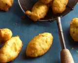 Goldbraune Dauphine Kartoffeln, frisch frittiert und auf einem Abtropfsieb. Ein Genuss für jeden Kartoffelliebhaber.