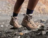 Botas de montaña Forclaz de color marrón, con cordones, sobre terreno rocoso.