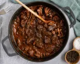 Herzhafter Rehgulasch in dunkler Sauce, bereit zum Schmoren. Die Frage "reh gulasch wie lange schmoren" wird hier visuell beantwortet: lange und langsam für zartes Fleisch.