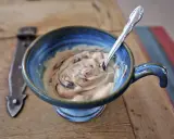 En skål med krämig egen isglass utan socker, virvlad med choklad. En sked vilar i den blå keramikskålen.