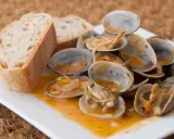 Almejas a la marinera, jugosas y sabrosas, servidas con pan rústico para mojar en la deliciosa salsa.