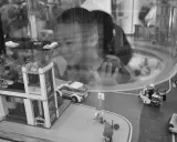 Bambina osserva con stupore un **reportage fotografico** di idee con costruzioni Lego: un commissariato, auto della polizia e personaggi in azione.