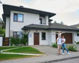 Rodzina przed nowoczesnym domem. Zastanawiasz się, ile trwa budowa domu 100m2?