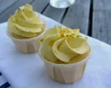Två läckra citron cupcakes med gul frosting och strössel. Perfekt för en fika.