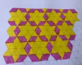 Tassellazioni scuola primaria: un pattern di triangoli gialli e rombi viola su carta a quadretti, un esercizio di geometria creativa.