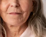 Gros plan sur le visage d'une femme âgée, montrant les rides autour de la bouche et du cou. Des conseils sur comment faire disparaître les rides profondes pourraient être utiles.