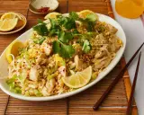 Pyszne pad thai co to? Danie z kurczakiem, makaronem ryżowym, orzeszkami ziemnymi i świeżą kolendrą, podane z cytryną.