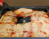 Ania gotuje pizzę. Gorąca, domowa pizza z serem i szynką, właśnie wyjęta z blachy.