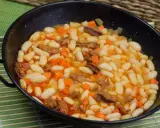 Alubias con chorizo y verduras en una paellera, plato tradicional español.