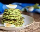 Pila di rosti di zucchine dorati, guarniti con spicchi di uovo sodo. Un piatto leggero e gustoso.