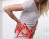 Kobieta z bólem w boku, wskazującym na kamicę nerkową, która może powodować ból nóg.