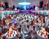 Festa in bianco a bordo della MSC Divina, con centinaia di persone che ballano e si divertono in un'atmosfera vibrante.