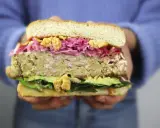 Hamburguesa de pollo con aguacate, col morada y crujientes trozos. ¡Una delicia!