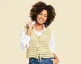 Mujer sonriente con chaleco de crochet con patrón calado, atado al frente.