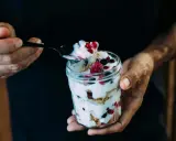 Ein Glas Magerquark mit Beeren, perfekt für den Muskelaufbau. Eine Löffelspitze voller Genuss.
