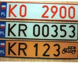 Kolekcja tablic rejestracyjnych świata: polskie tablice KO 2900, KR 00353 i KR 123 z zabytkowym autem.