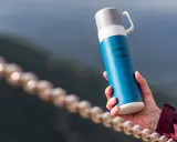 Idealny termos w góry – niebieski Hi-Tec z napisem "Mountains are calling". Idealny towarzysz każdej wyprawy.
