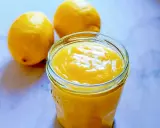 Un pot de lemon curd sans maïzena, onctueux et doré, à côté de deux citrons frais. Parfait pour une touche acidulée.