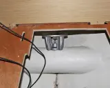 Installation d'un propulseur d'étrave : pièce métallique argentée fixée dans une ouverture, câbles noirs visibles.