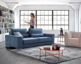 Salon moderne avec canapé bleu, fauteuil beige et bibliothèque. Quelle couleur de canapé choisir pour un style contemporain ?