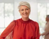 Uśmiechnięta kobieta z krótkimi blond włosami, w czerwonej bluzce. Idealna inspiracja na eleganckie fryzury na wesele dla mamy.