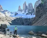 Widok na majestatyczne Torres del Paine w Chile. Turysta podziwia turkusowe jezioro i ośnieżone szczyty.