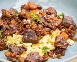 Herzhaftes Wildschwein Gulasch Rezept mit Spätzle, garniert mit frischen Kräutern und grobem Salz. Ein Genuss für Feinschmecker!