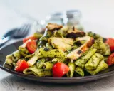 Penne z kurczakiem i pomidorkami, obficie polane aromatycznym makaronem z pesto bazyliowym. Pyszny obiad gotowy!
