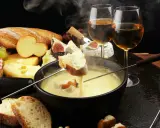 Un délice fumant de fondue au fromage, pain croustillant et vin blanc. Un aperçu des spécialités Auvergne Rhône Alpes.