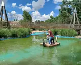 Un padre y sus hijos disfrutan de un día de aventura en un parque acuático en Valladolid con niños, navegando en una balsa.