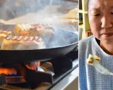 Halloumi steks i panna på spisen, ånga stiger. En kvinna njuter av en bit grillost på en gaffel. Ett enkelt grillost recept.