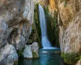 Cascada cayendo en pozas cristalinas, un rincón idílico de piscinas naturales Alicante.