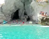 Bambini e adulti si divertono nella grotta del Palombaro, tra scogli e acque cristalline.