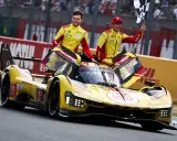 Zwei Rennfahrer in gelb-roten Overalls jubeln neben ihrem gelben Ferrari Le Mans Prototyp mit der Startnummer 83.
