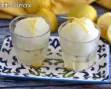 Dos vasos de sorbete de limón, refrescante y con un toque de ralladura de limón, listos para disfrutar.