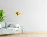 Nowoczesny kinkiet geometryczny z drewnianymi i metalowymi elementami, tworzący ciepłe światło.