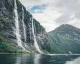 Siedem Sióstr, wodospad w Geirangerfjordzie, to jedno z najpiękniejszych miejsc w Norwegii. Woda spływa kaskadami po skalnej ścianie, tworząc spektakularny widok.