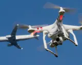 Eine Drohne fliegt in Deutschland nah an einem Flugzeug vorbei.